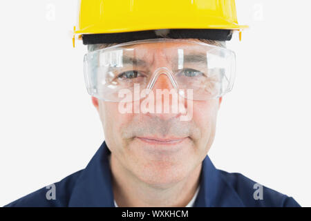 Closeup ritratto di meccanico di indossare casco e occhiali protettivi su sfondo bianco Foto Stock