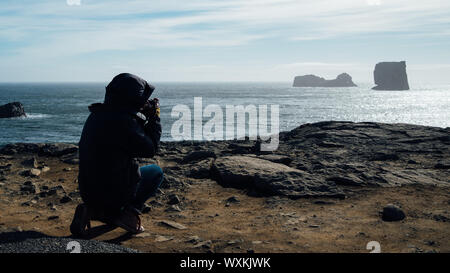 Silhouette di donna in camicia da dietro su una spiaggia in Islanda Foto Stock