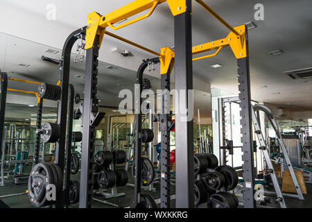 Luce moderna palestra. Attrezzature sportive in palestra. Barbells di diverso peso sul rack. Foto Stock