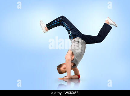 Pausa Bilanciamento del ballerino sul suo gli avambracci su sfondo blu Foto Stock