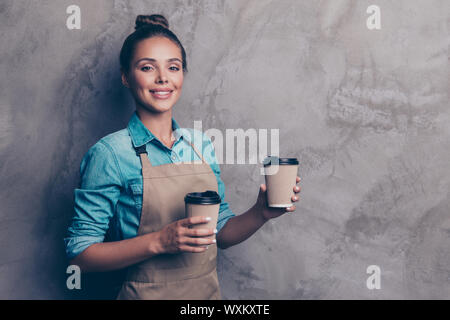 Piuttosto, sognante, affascinante ragazza detiene tazza monouso con bevande a Foto Stock