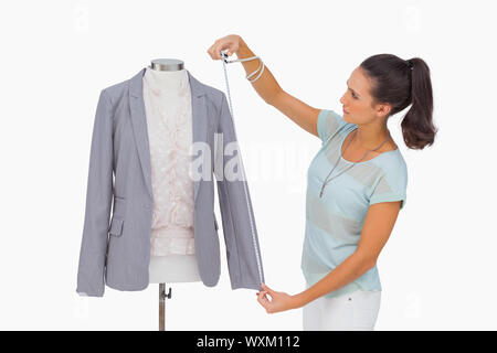 Designer di moda la misurazione blazer manicotto sul manichino su sfondo bianco Foto Stock