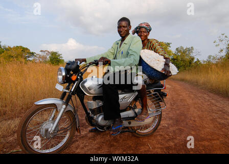 MALI , Bougouni , imprenditore harvest fair trade in cotone organico, donna con marito e resa cotone dopo il raccolto sul motociclo / MALI , Bougouni, commercio equo und Biobaumwolle Projekt , Biofarmerin Kéniba Samake mit ihrem Mann Daouda Samaké aus Dorf Faragouaran Foto Stock