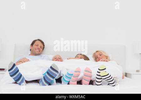 Famiglia stripey indossare calze a casa nel letto Foto Stock