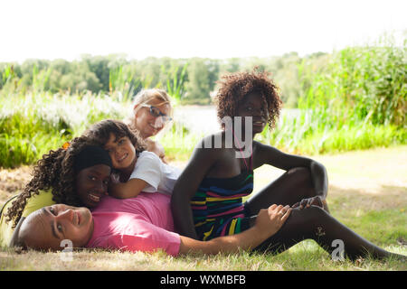 Felice famiglia multiculturale avente un bel giorno di estate Foto Stock