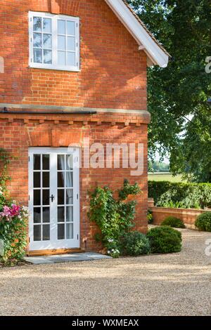 Porte francesi e le tradizionali finestre in legno sulla parte esterna di una casa in Inghilterra, Regno Unito Foto Stock