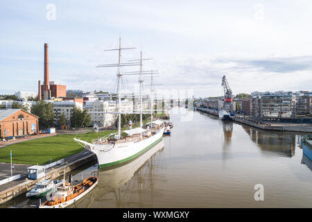 Turku, Finlandia - 09/09/2019: Cigno di Finlandia nave sul fiume Aurajoki con energia di Turku e camino Föri ferry in background in Turku, Finlandia Foto Stock