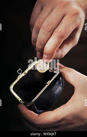 L'uomo prendendo l'ultimo Euro moneta dal suo piccolo portamonete. Molto breve di profondità di campo. Foto Stock