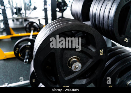 Luce moderna palestra. Attrezzature sportive in palestra. Barbells di diverso peso sul rack. Foto Stock