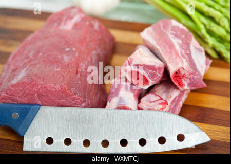 Materie di manzo e costolette di maiale con asparagi e erbe pronto per cucinare Foto Stock