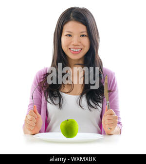 Mangiare sano concetto. Ragazza asiatica tenendo pronti a mangiare mela verde sulla piastra. Isolato su sfondo bianco. Foto Stock