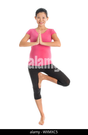 Yoga prenatale di classe. Lunghezza completa asiatici sano donna incinta facendo esercizi yoga stretching, corpo pieno isolati su sfondo bianco. Foto Stock