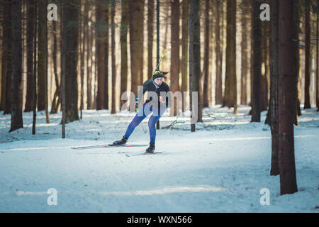 Sci di fondo donna classica facendo Nordic sci di fondo nel sentiero tracce nella neve coperto foresta. Via di formazione per gli sciatori nel parco di Foto Stock