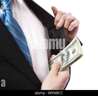 Uomo d'affari mettendo un batuffolo di contanti nella sua tuta nella tasca di una giacca su sfondo bianco Foto Stock