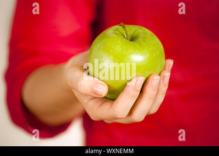 Foto di una donna di mano azienda o dando una mela verde. Profondità di campo. Foto Stock