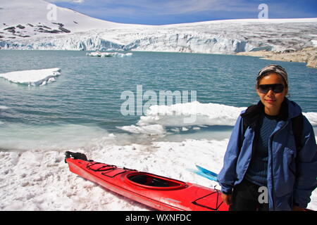 Il kayak donna di fronte del ghiacciaio Jostedal in Norvegia. Foto Stock