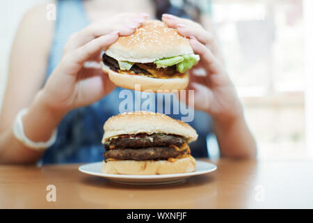 Donna mangia hamburger Foto Stock