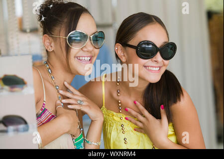 Ragazze cercando su occhiali da sole Foto Stock