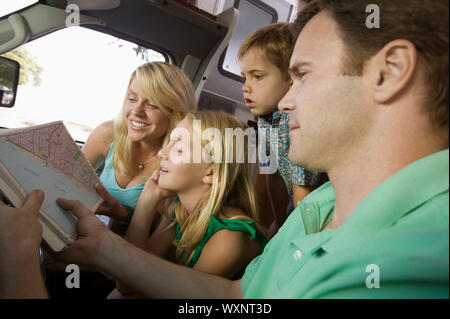 Famiglia in RV guardando la mappa stradale Foto Stock