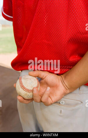 Lanciatore di baseball di tenuta dietro la schiena Foto Stock