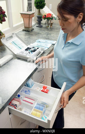 Igienista dentale cercando nel cassetto di alimentazione Foto Stock