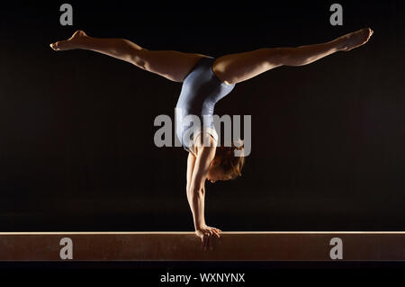 Facendo ginnasta Split Handstand sul fascio di equilibrio Foto Stock
