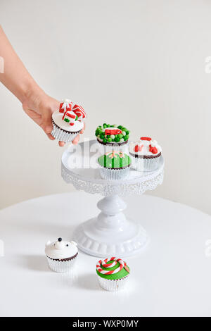 Stagionale festa di Natale mini dessert tortine nel tradizionale rosso verde simboli decorativi elementi Foto Stock