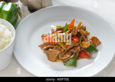 Tipico piatto cinese,carni bovine fresche saltate in padella con pepperrs germogli di bambù e funghi Foto Stock