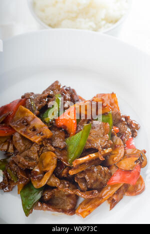 Tipico piatto cinese,carni bovine fresche saltate in padella con pepperrs germogli di bambù e funghi Foto Stock