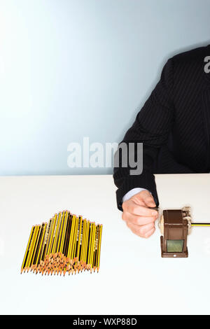 Imprenditore affilatura di un sacco di matite Foto Stock