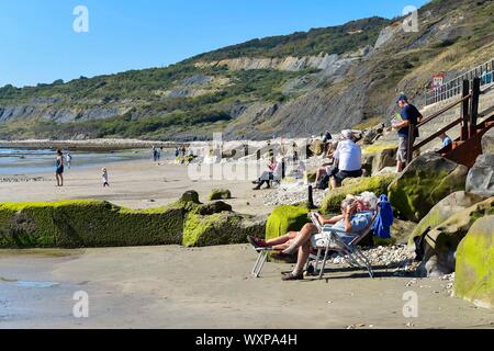 Charmouth, Dorset, Regno Unito. Xvii Sep, 2019. Regno Unito Meteo. Visitatori sulla spiaggia a Charmouth nel Dorset godersi il caldo sole autunnale e il cielo limpido. Credito Foto: Graham Hunt/Alamy Live News Foto Stock