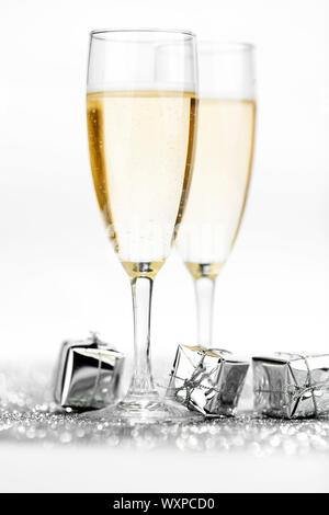 Due champagne flauti e doni su sfondo lucido Foto Stock