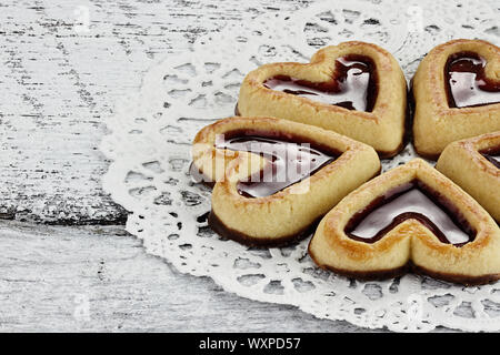 A forma di cuore biscotti frollini in un cerchio su un sfondo rustico. Foto Stock
