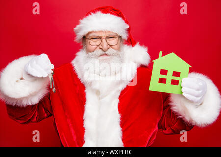 Scelta scegliere successo noel eve immobiliare di concetto. Età matura elegante fantasia Nicholas in costume guanti barba bianca isolata su rosso sfondo luminoso Foto Stock