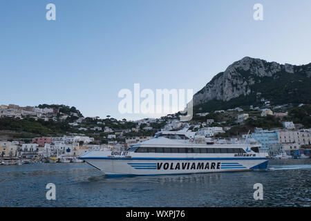 Ferry boat lasciando Marina grande sull'Isola di Capri al tramonto in estate Italia Foto Stock