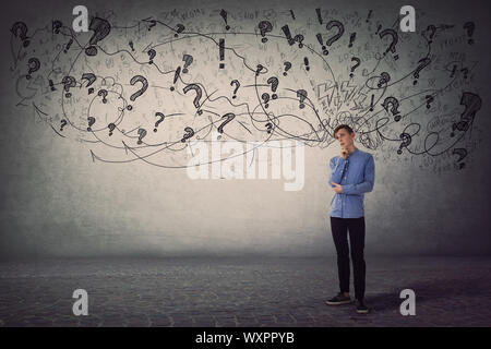 Sconvolto e premurosa teen guy, mano al mento, non ha idee per la caratteristica di essere nella disperazione. Adolescente di emozioni negative e concetti, pasticcio in Foto Stock