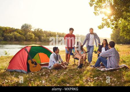 Un gruppo di amici hanno un pic-nic in un bosco in autunno. Foto Stock