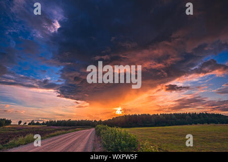 Campo estivo con il percorso e il Cielo di tramonto sopra. Bel tramonto paesaggio. Foto Stock