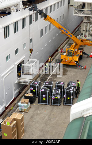 Lavoratori con una sterlina gru per caricare le forniture su una nave da crociera nel porto di Vancouver, Vancouver, B. C., Canada Foto Stock