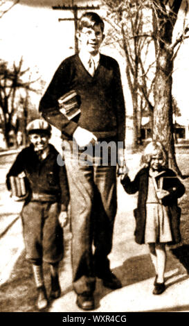 Robert Pershing Wadlow (1918-1940), noto come il Gentle Giant, la Alton gigante e il gigante dell'Illinois. Egli è ampiamente riconosciuto come il più alto verificato persona registrata nella storia (2,72 m) . Questa 1930 Immagine mostra di lui come uno scolaro con altri due ragazzi che si ritiene essere il fratello e la sorella. Wadlow appartenne all'ordine di DeMolay,e divenne in seguito un Maestro Muratore. Foto Stock