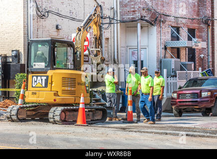 HICKORY, NC, Stati Uniti d'America-13 Settembre 2019: operai stradali e Caterpillar CAT (305E) sulla strada della citta'. Foto Stock