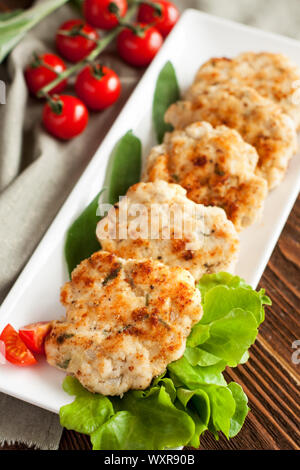 In casa polpette di pollo con aglio e salvia serviti con insalata di lattuga e pomodoro ciliegino Foto Stock