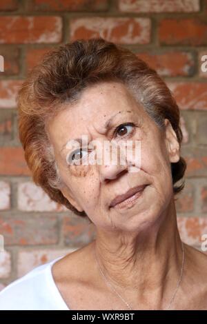 Ritratto di una donna anziana con la sua testa inclinata e un sguardo pensieroso Foto Stock