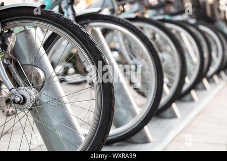 Noleggio biciclette parcheggiate in una fila. Foto Stock