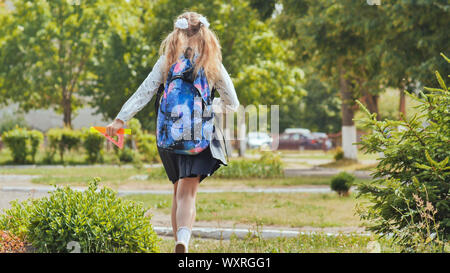 Felice undici anni di schoolgirl corre con uno zaino dopo la scuola. Foto Stock