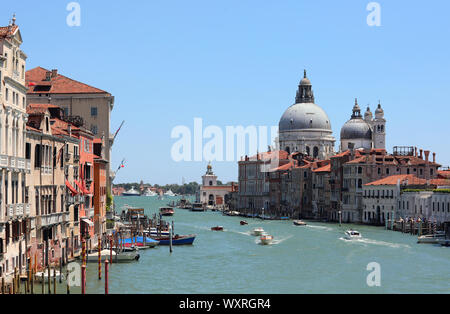 Vista tipica dell'isola di Venezia in Italia con il Canal Grande che è la principale via di comunicazione della città e la grande cupola della chiesa Foto Stock