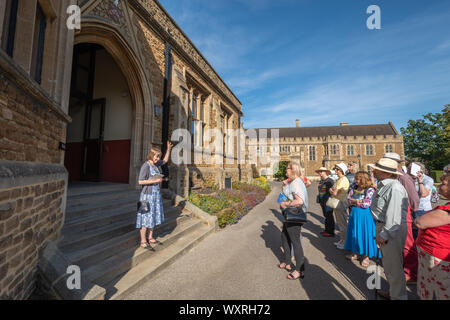 I visitatori al di fuori della Hall in un tour guidato del Charterhouse, una storica boarding school in Surrey, Inghilterra, Regno Unito. Foto Stock