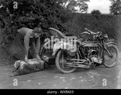 AJAXNETPHOTO. 1910 (circa). In Inghilterra. - TOURING in motocicletta - una signora prepara un pacchetto di riporre sulla parte posteriore di un sidecar di vimini; la moto è una ZENITH. fotografo:sconosciuto © IMMAGINE DIGITALE COPYRIGHT VINTAGE AJAX Picture Library Fonte: AJAX FOTO VINTAGE COLLEZIONE REF:()AVL TRA MBIKE JB 80201 54 Foto Stock