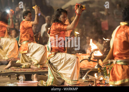 Un gruppo di devoti di eseguire la preghiera della sera presso la banca del fiume di Varanasi Foto Stock