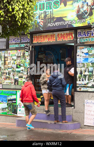 BANOS, ECUADOR - 25 FEBBRAIO 2014: Persone non identificate presso l'agenzia di viaggi e tour operator di Geotours in via Ambato il 25 febbraio 2014 a Banos Foto Stock